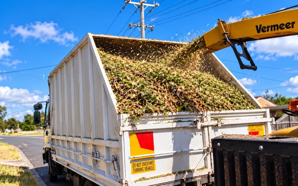 Commercial Vermeer wood chipper chute filling tipper truck in Townsville